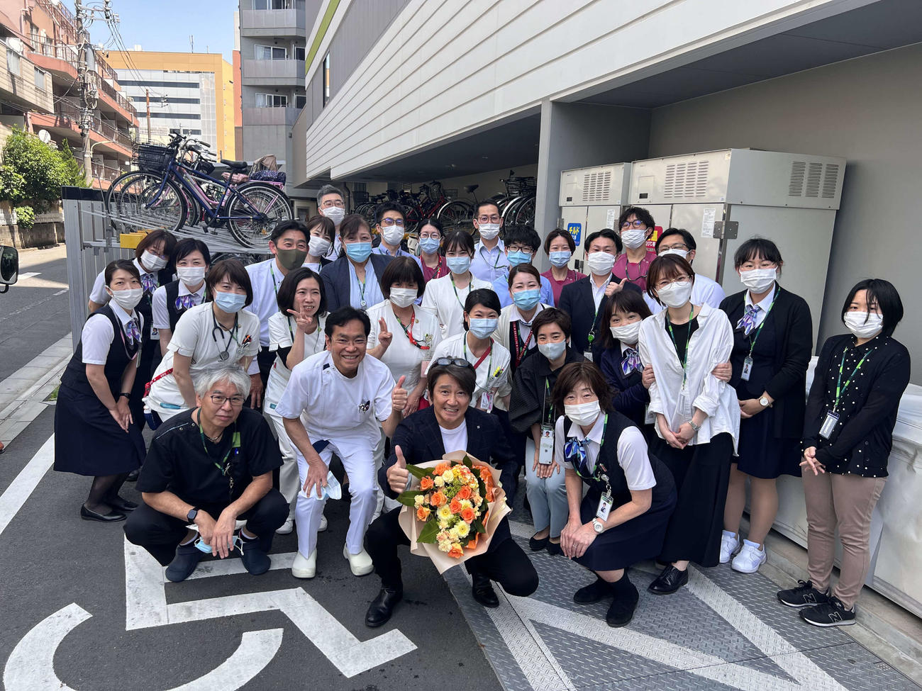 退院して花束を手に病院関係者に囲まれる近藤真彦