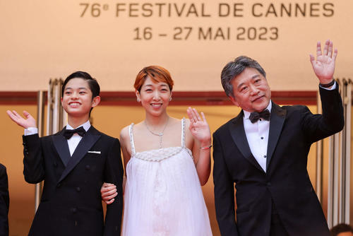 カンヌ映画祭公式上映前にレッドカーペットを歩き、歓声に応える映画「怪物」の、左から黒川想矢、安藤サクラ、是枝裕和監督