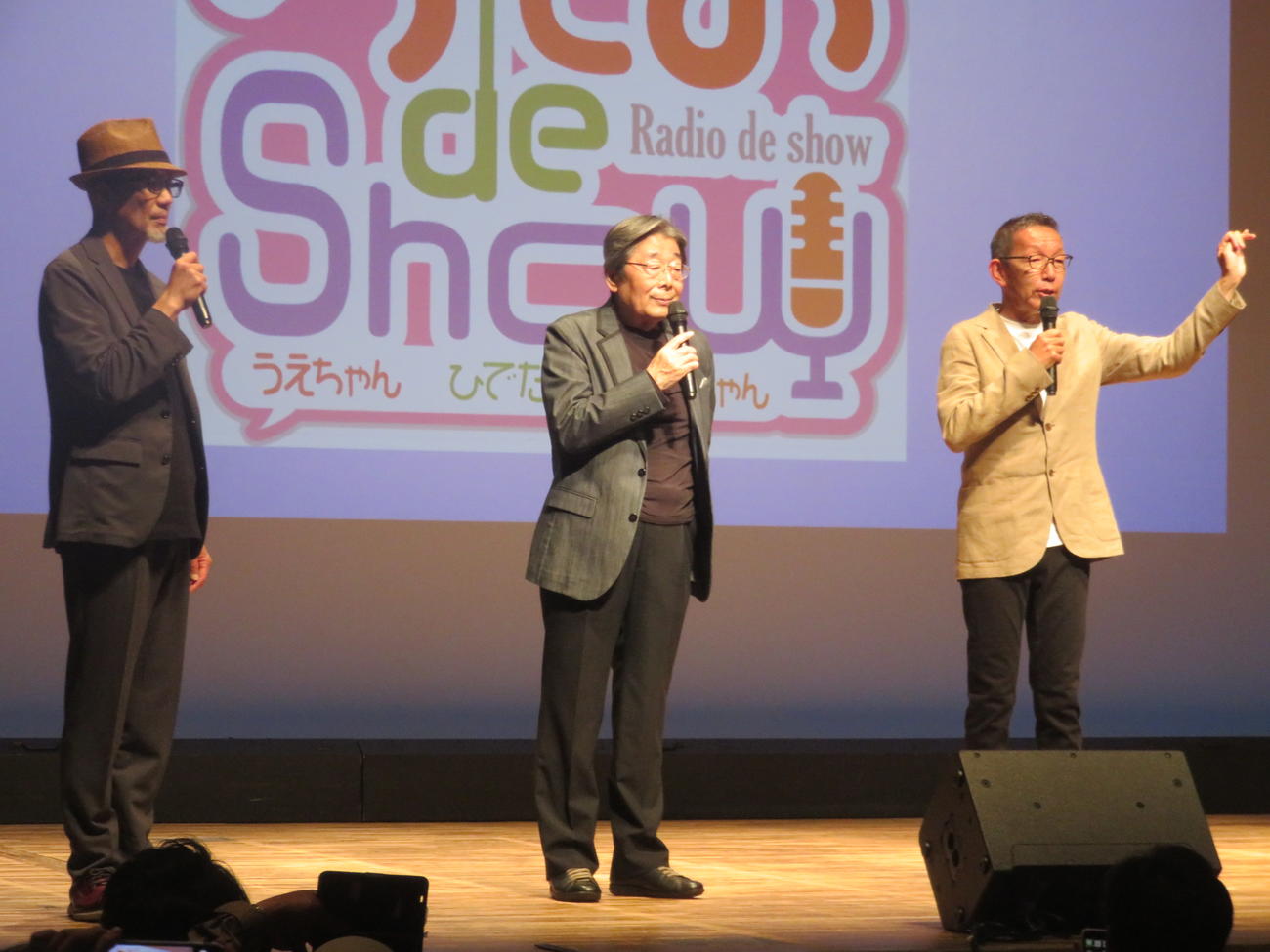 トークライブ「らじお　de Show」のステージ上から観客の声援に応える、左から上柳昌彦、高嶋ひでたけ、松本秀夫