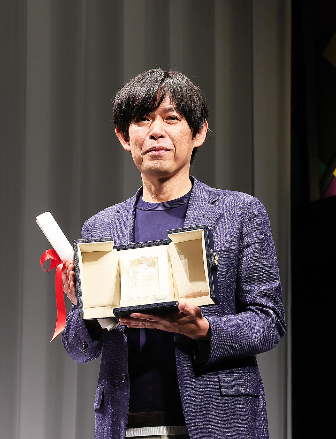 カンヌ国際映画祭「脚本賞」を受賞し凱旋会見でトロフィーを手に笑顔を見せる坂元裕二氏（撮影・足立雅史）