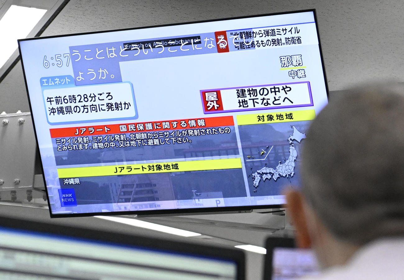 北朝鮮がミサイルを発射したことを伝えるテレビの画面（共同）