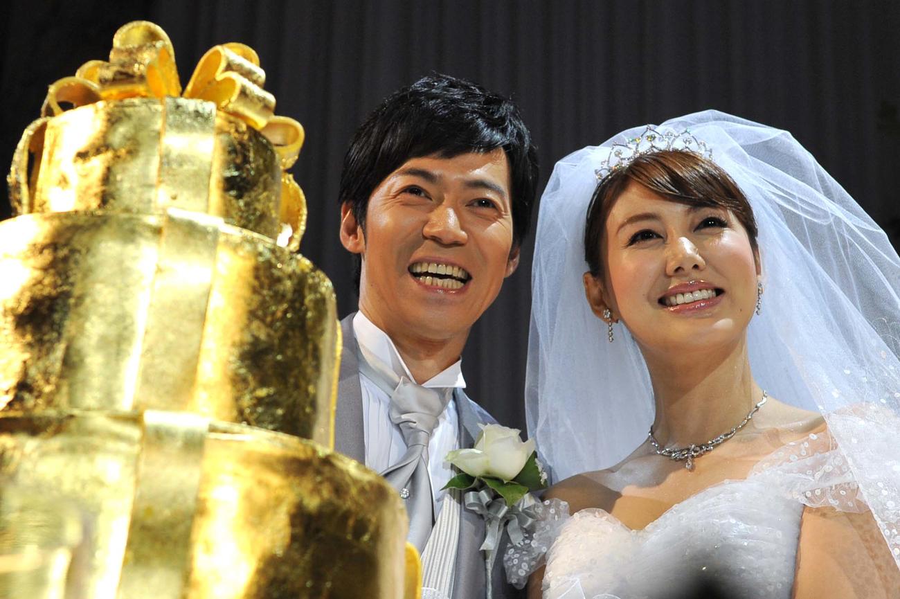 金のウエディングケーキを前に笑顔を見せる東貴博（左）と安めぐみ（2012年7月撮影）