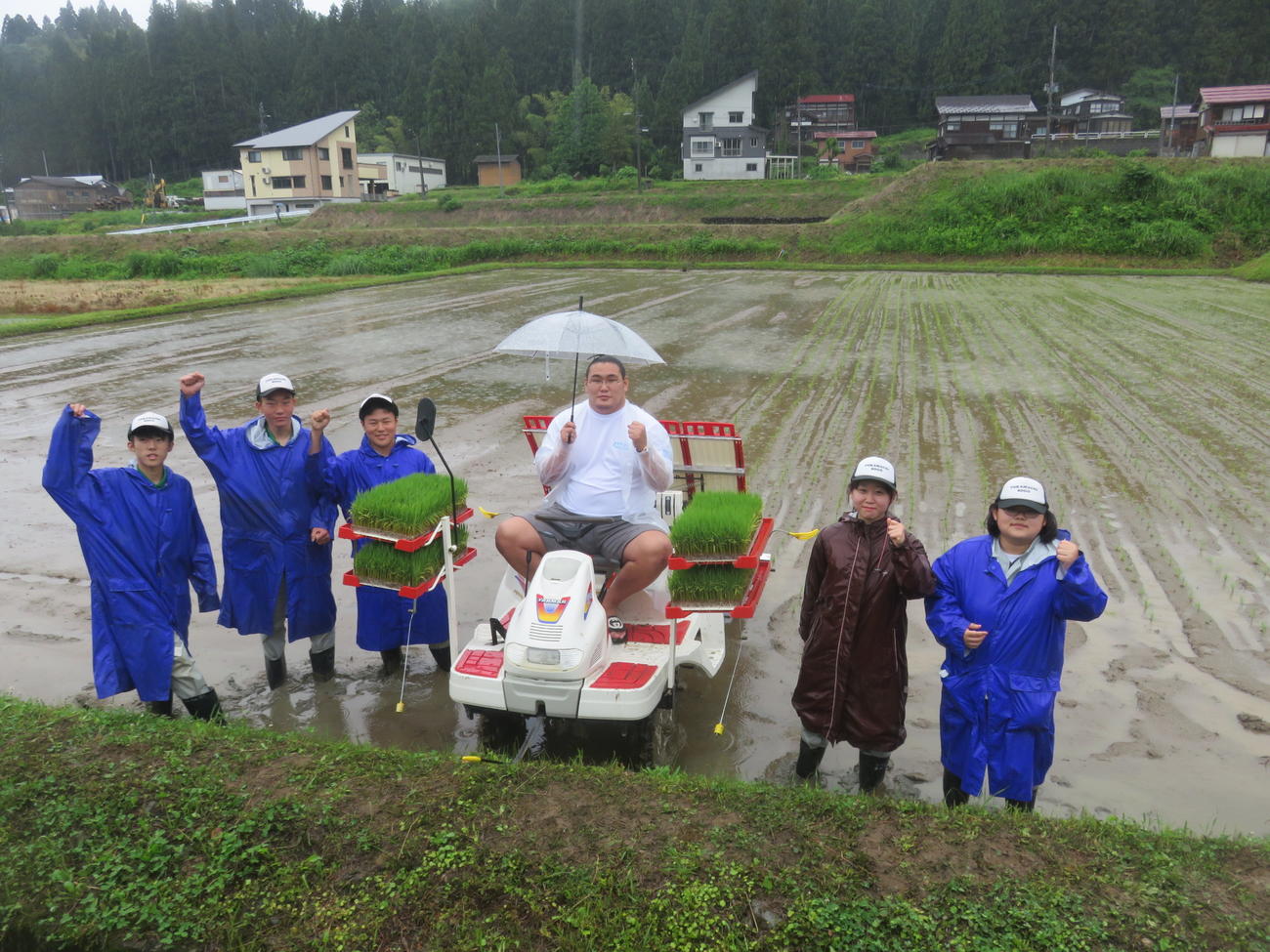 「越後情話立浪部屋ファーム」で行われたブランド米「越後情話」の田植えセレモニーで、地元の十日町総合高校の生徒たちに囲まれる関脇豊昇龍