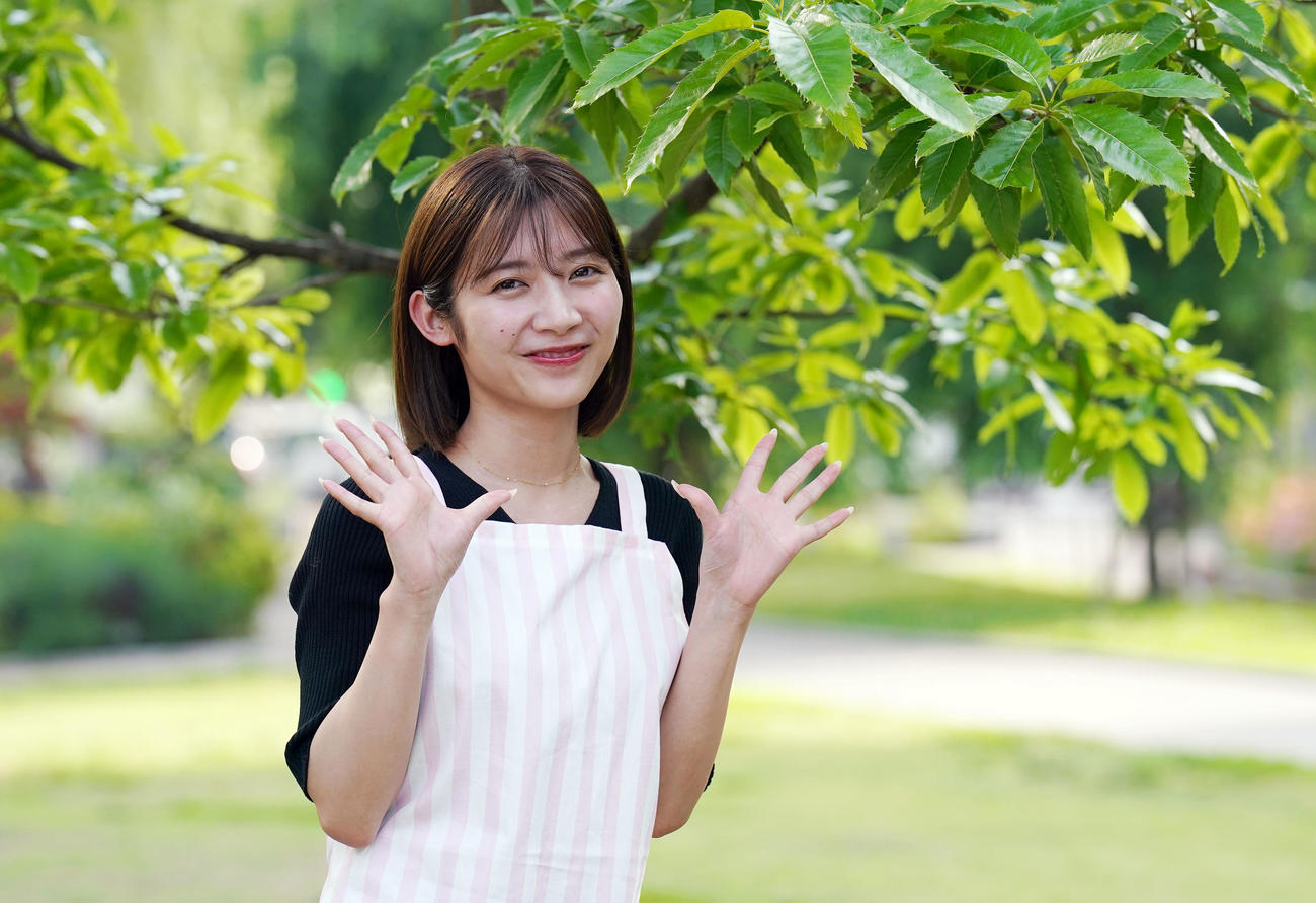 公園の緑に囲まれ、笑顔を見せる伊藤梨沙子さん（撮影・狩俣裕三）
