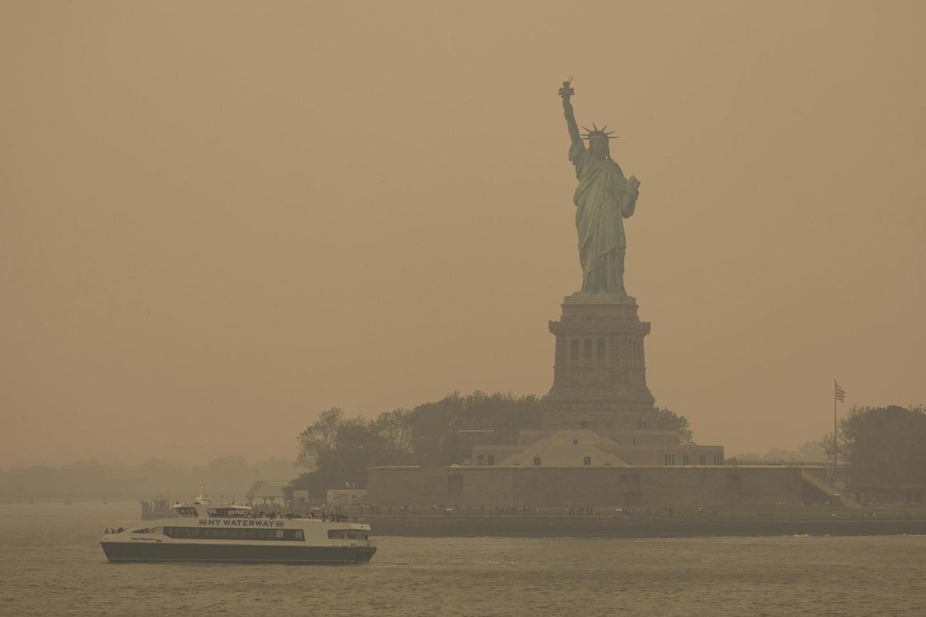 7日、もやに覆われた米ニューヨークの自由の女神像（AP＝共同）