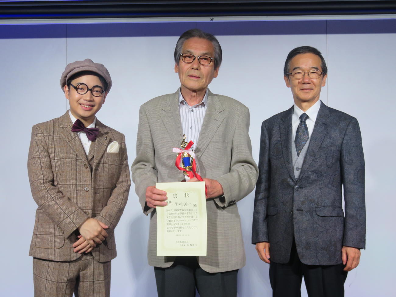 三丘翔太（左）と水森英夫氏（右）に囲まれる優勝者の柴崎誠一さん