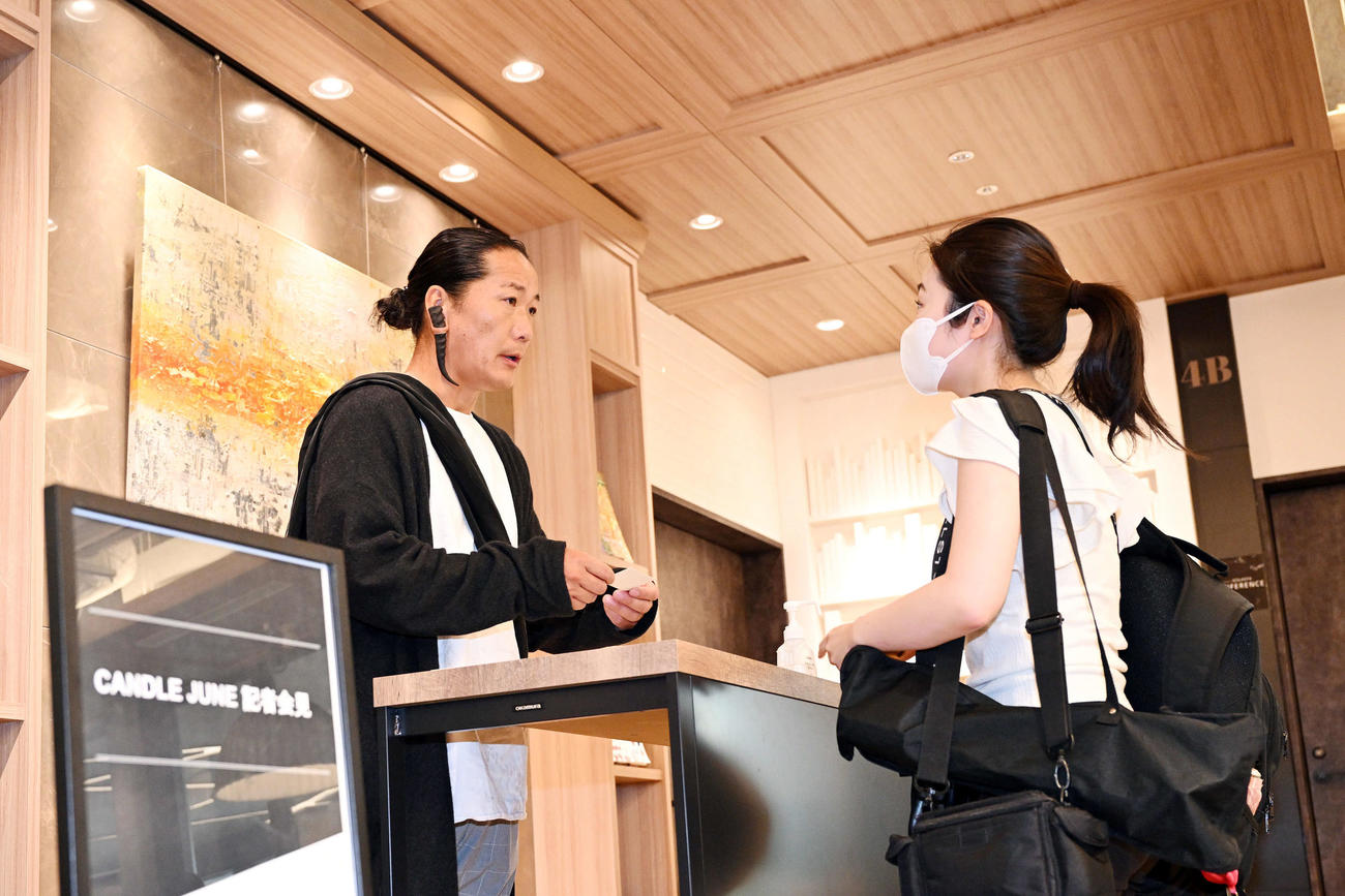 会見の受け付けをするキャンドル・ジュン氏（左）（撮影・滝沢徹郎）