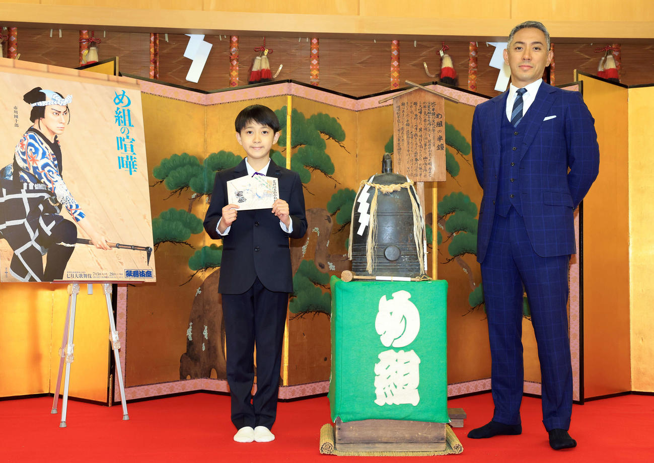 七月歌舞伎「神明恵和合取組　め組の喧嘩」の成功祈願に訪れた芝大神宮で半鐘を挟み、記念撮影する市川團十郎（右）と市川新之助（撮影・浅見桂子）