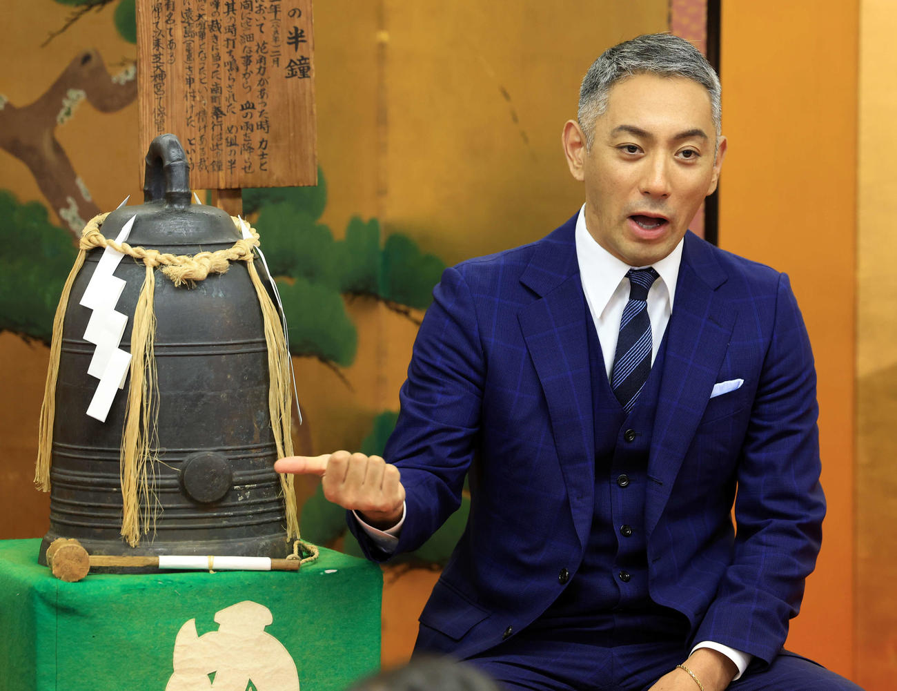芝大神宮にある年2度だけ披露される「め組の半鐘」の横で報道陣の質問に答える市川團十郎（撮影・浅見桂子）