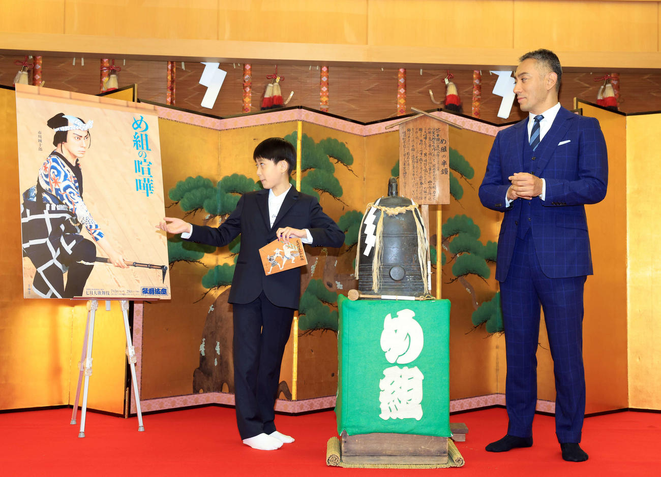 七月歌舞伎「神明恵和合取組　め組の喧嘩」の成功祈願に訪れた芝大神宮で前回の舞台写真を見て「お父さんに似てる」とポスターを指さす市川新之助（左）。右は市川團十郎（撮影・浅見桂子）