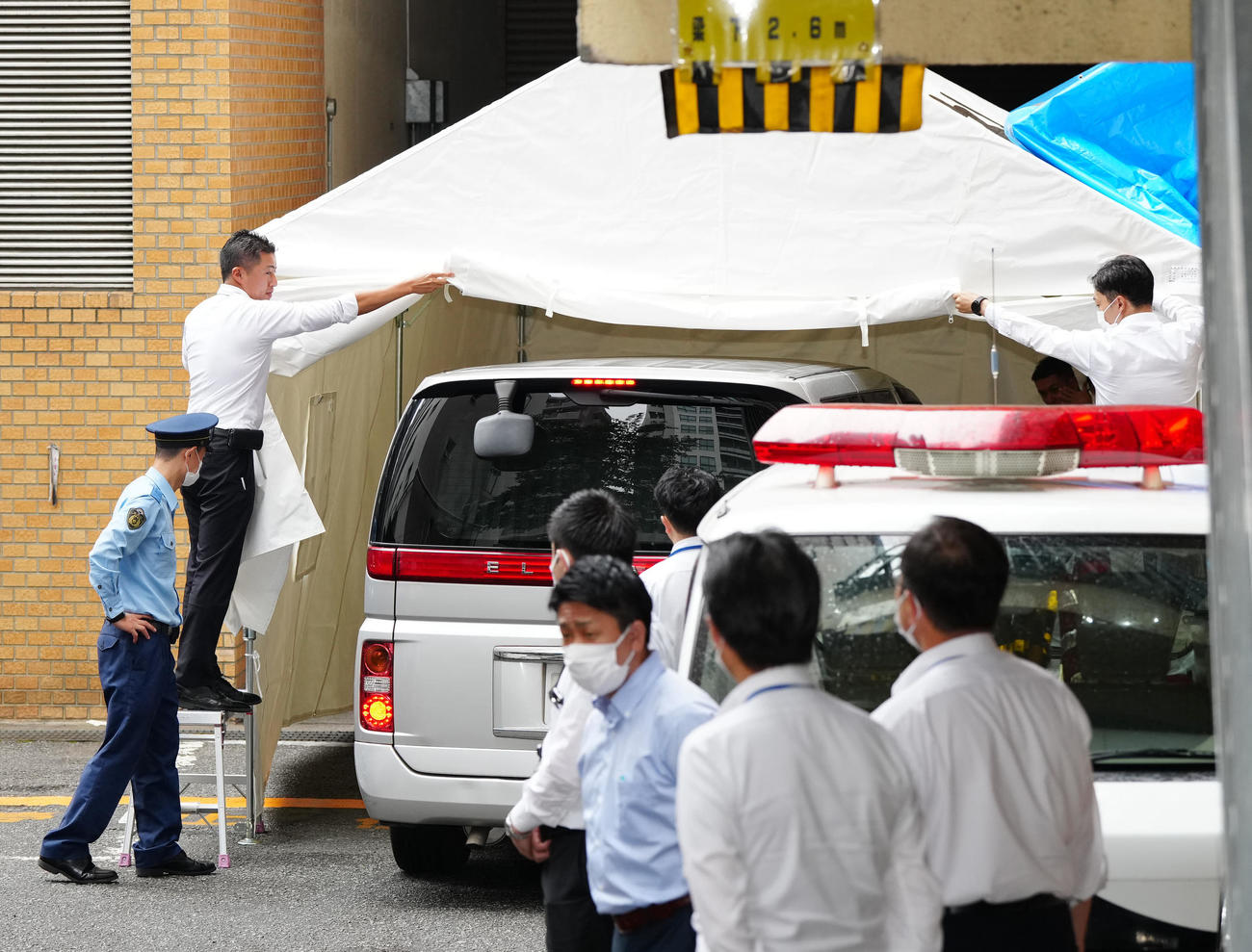 東京・目黒署で用意されたテントの中に入れられる市川猿之助容疑者を乗せた車両＝午前10時24分（撮影・江口和貴）