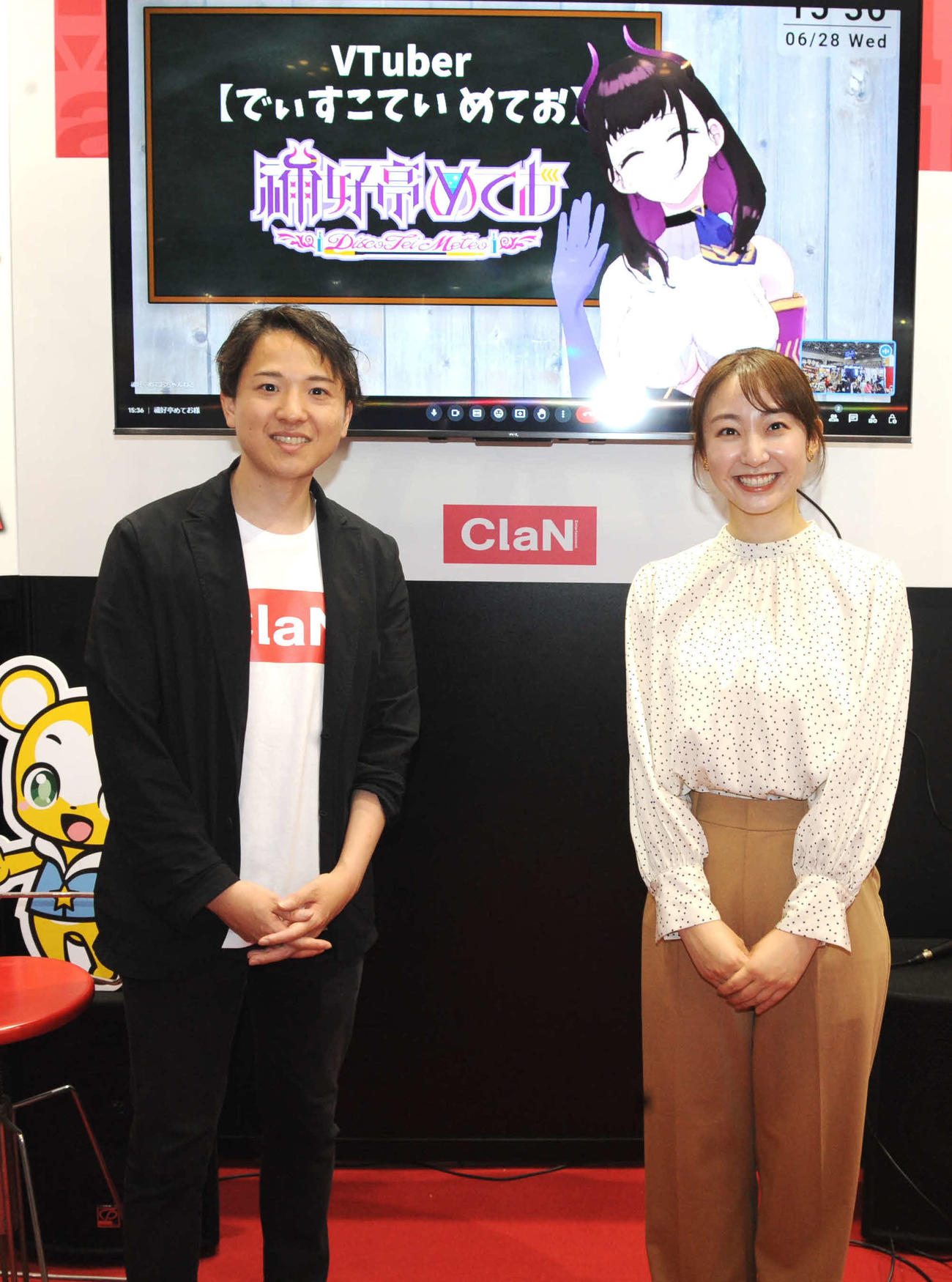 大規模国際総合展「コンテンツ東京」のClaN Entertainmentブースで対談した大井基行社長（左）と日本テレビの杉原凛アナウンサー。画面内はVTuberの禰好亭（でぃすこてい）めてお（撮影・松尾幸之介）