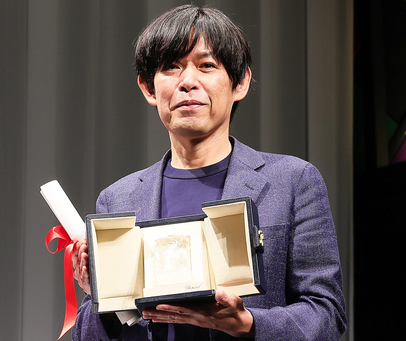 カンヌ国際映画祭「脚本賞」を受賞し凱旋会見でトロフィーを手に笑顔を見せる坂元裕二氏（撮影・足立雅史）