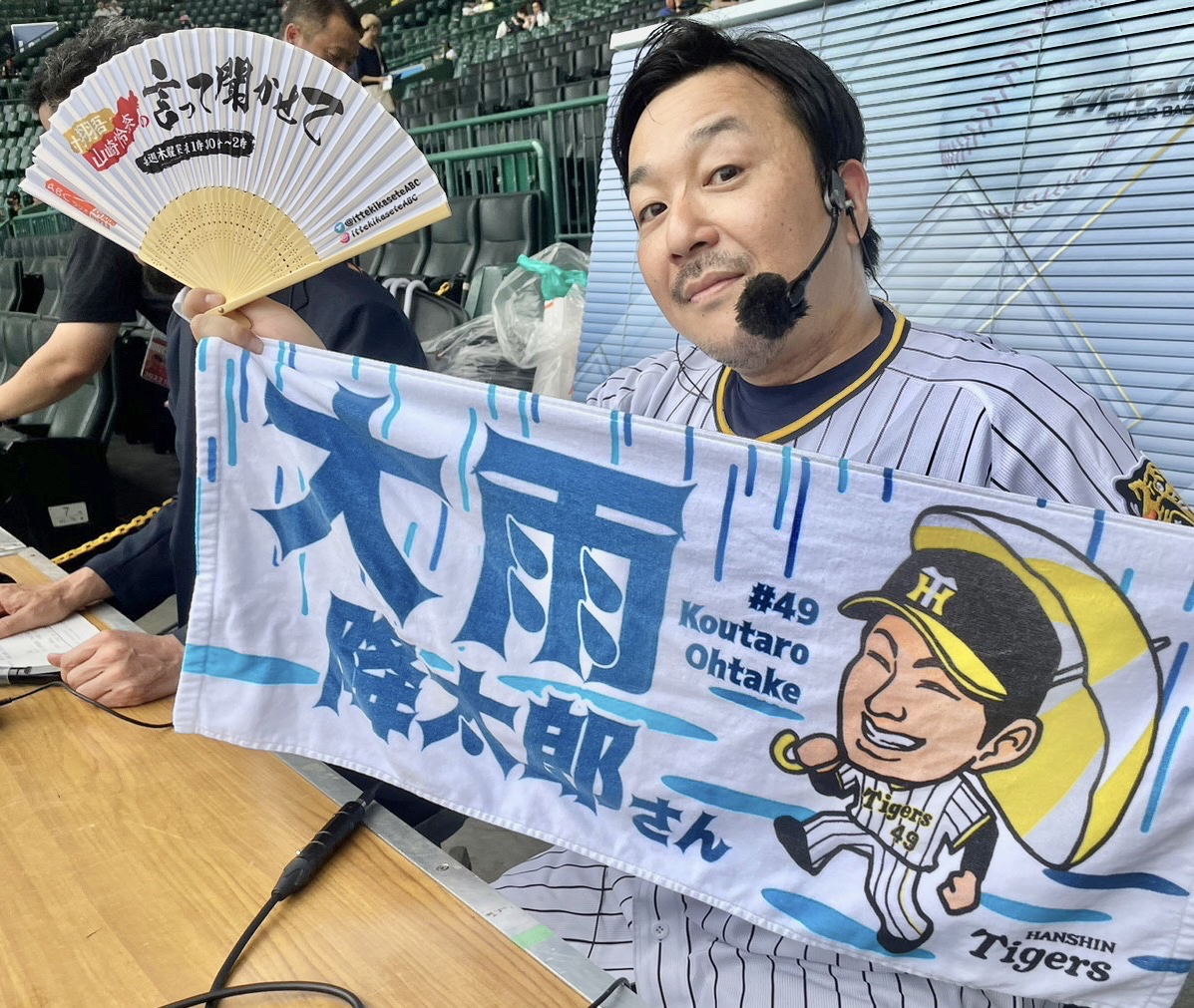 「大雨降太郎」と書かれたこの日の先発の大竹耕太郎投手のグッズのスタオルを手に持つ今村翔吾氏