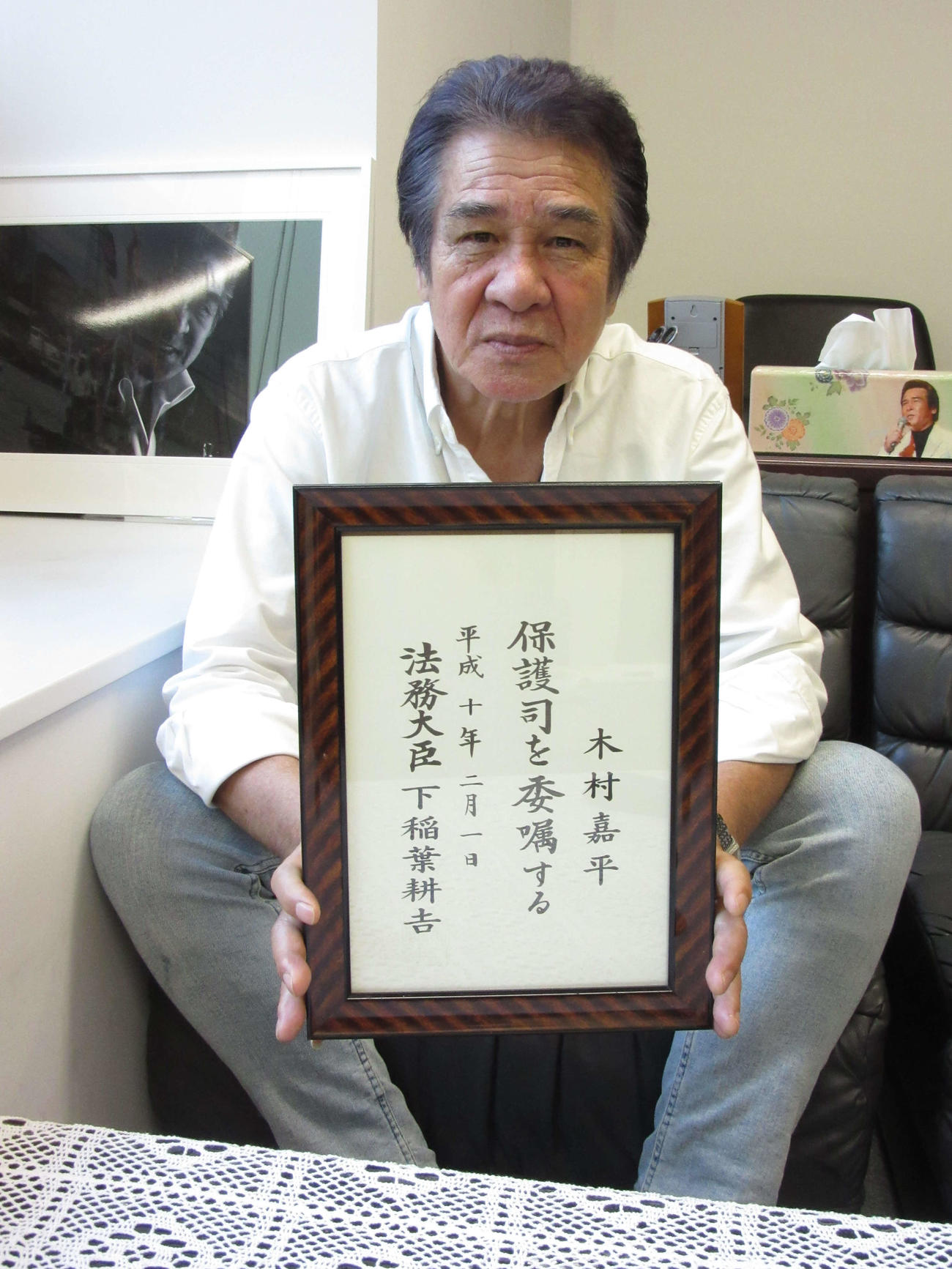 保護司の委嘱状を手にする鳥羽一郎