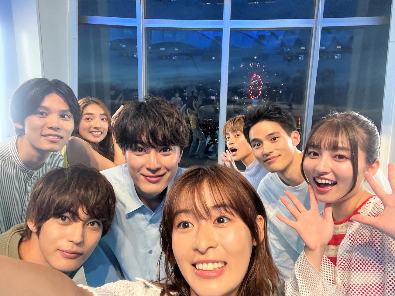 「真夏のシンデレラ」制作発表会見で打ち上げられた花火をバックに記念写真を撮影する森七菜（中央）。左手前から時計回りに神尾楓珠、萩原利久、仁村紗和、間宮祥太朗、白濱亜嵐、水上恒司、吉川愛（C）フジテレビ