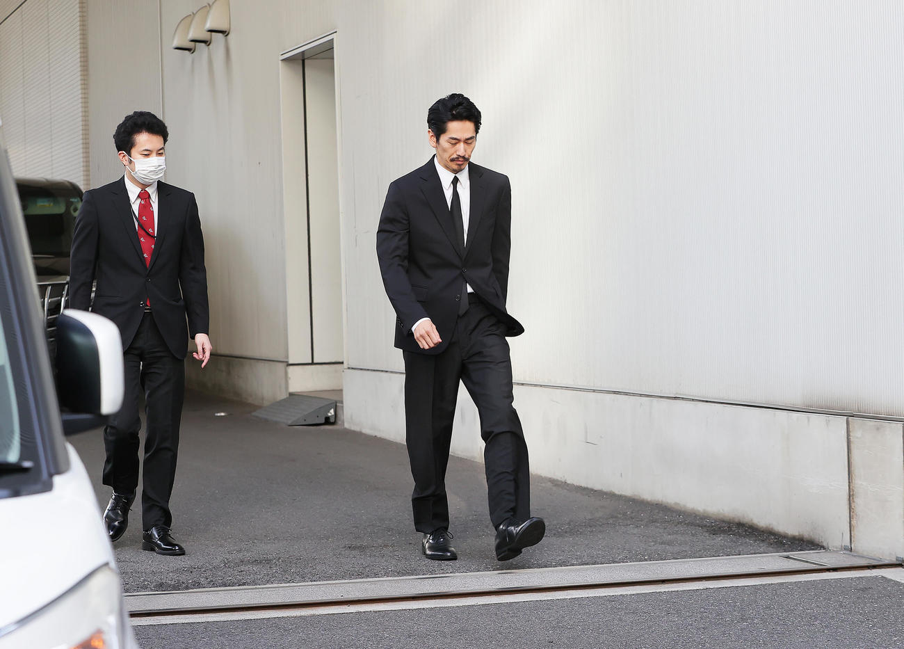 保釈された永山絢斗被告（右）はうつむきながら集まった報道陣の前へと向かう（撮影・足立雅史）