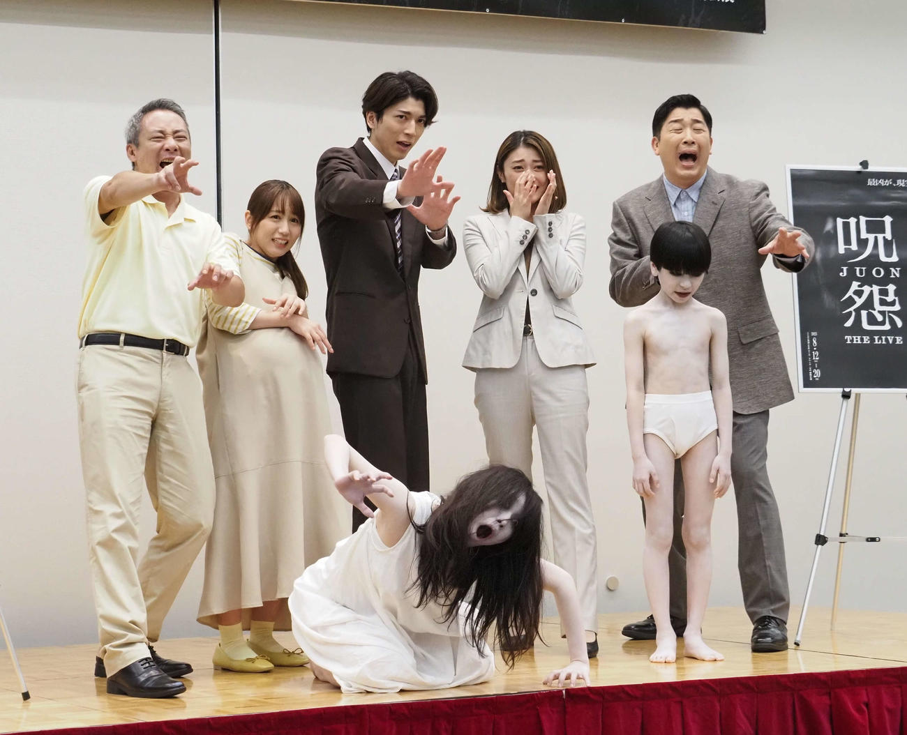 伽椰子、俊雄（手前）との記念撮影で怖がった表情を見せる登壇者。左からいしだ壱成、大場美奈、小松準弥、原幹恵、あべこうじ（撮影・遠藤尚子）