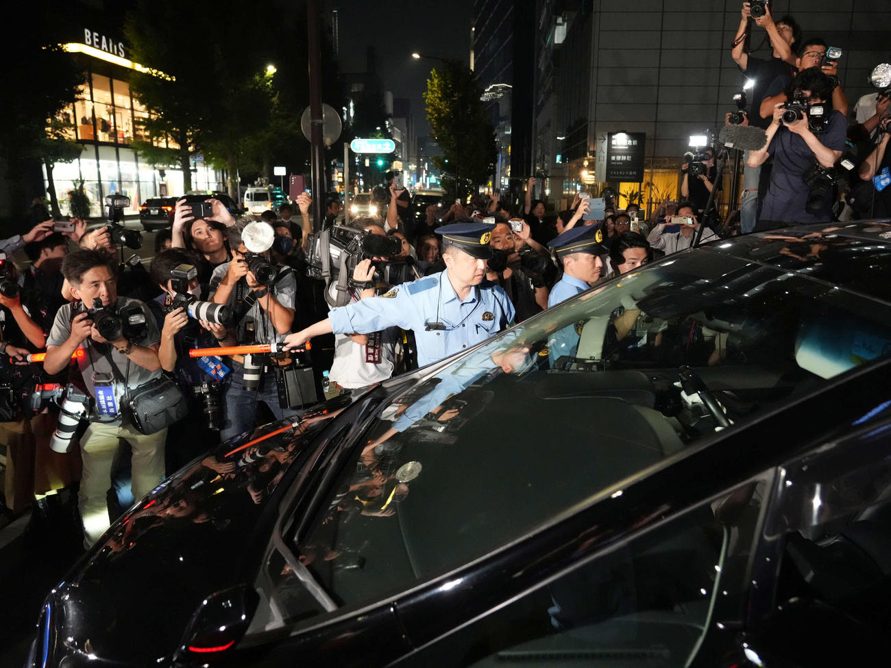 保釈された市川猿之助被告が乗った車は大勢の報道陣が取り囲むなか原宿署を後にする（撮影・小沢裕）