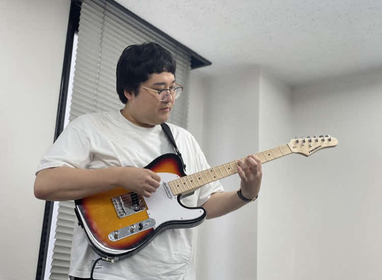テレ玉「それゆけ！　大宮セブン」でバンドを組み、ギターを担当するマヂカルラブリー村上（C）テレ玉