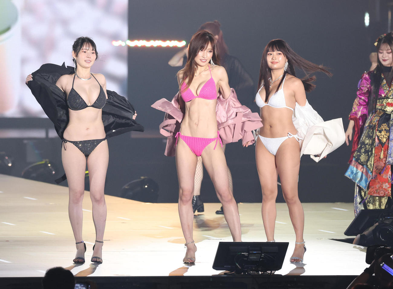 ランウエーで上着を脱いで水着姿になる左から、白川愛梨、熊田曜子、西本ヒカル（撮影・白石智彦）