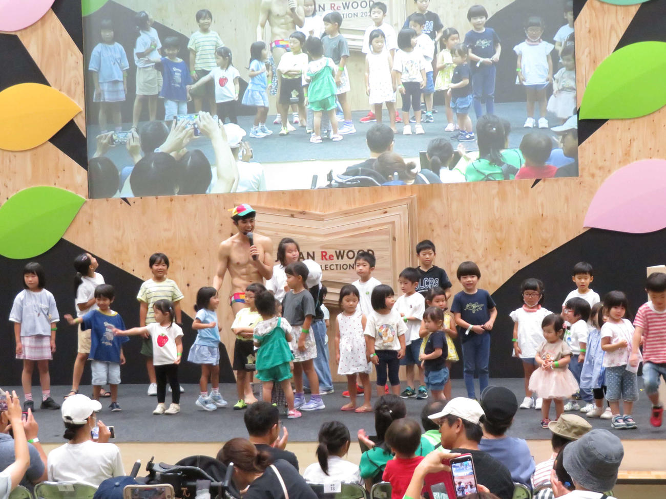 イベント「『木』のヒミツを学ピーヤ！」で、檀上に上がってきた子どもたちと触れ合う小島よしお（撮影・村上幸将）