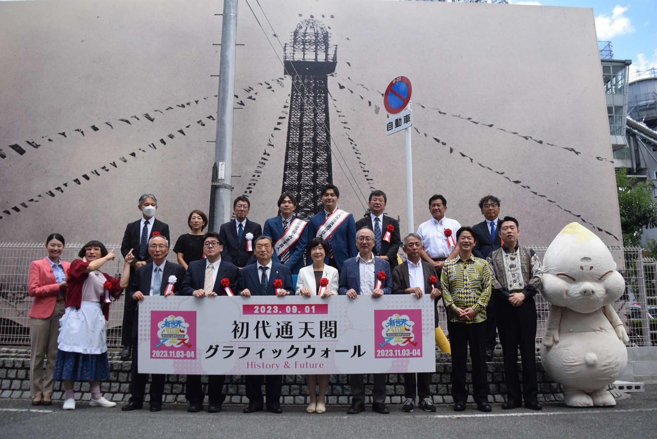 グラフィックウォールでよみがえった初代通天閣を前にポーズを取る鮫島幸恵（前列左端）とすっちー（同左から2人目）（撮影・阪口孝志）