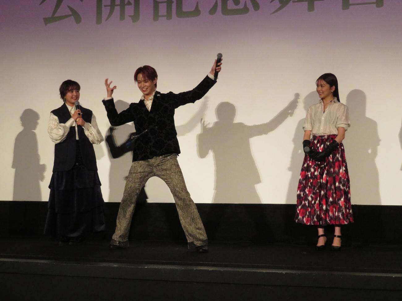 映画「夜が明けたら、いちばんに君に会いにいく」公開記念舞台あいさつの檀上で踊るJ01白岩瑠姫（中央）と見守る箭内夢菜と1人おいて久間田琳加（撮影・村上幸将）
