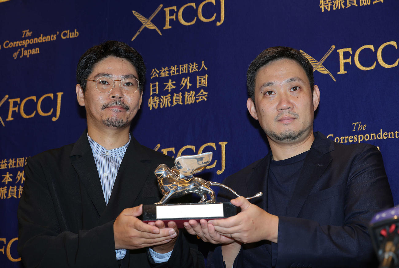 「悪は存在しない」ベネチア国際映画祭報告記者会見で、銀獅子賞のトロフィーを手に写真に納まる濱口竜介監督（右）と主演を務めた大美賀均（撮影・河田真司）