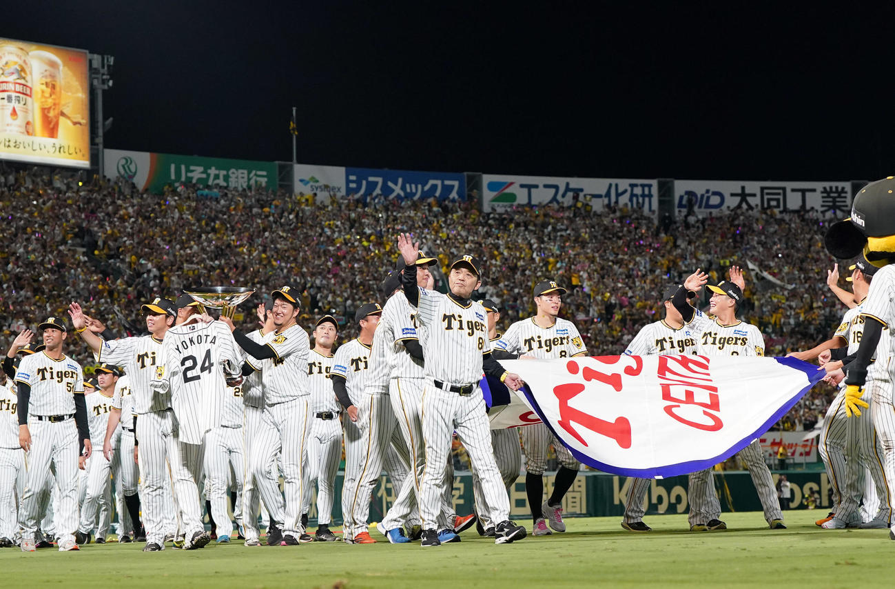 阪神対巨人　リーグ優勝を決め、優勝ペナントを手に場内1周をする岡田監督（中央）と選手たち（撮影・狩俣裕三）