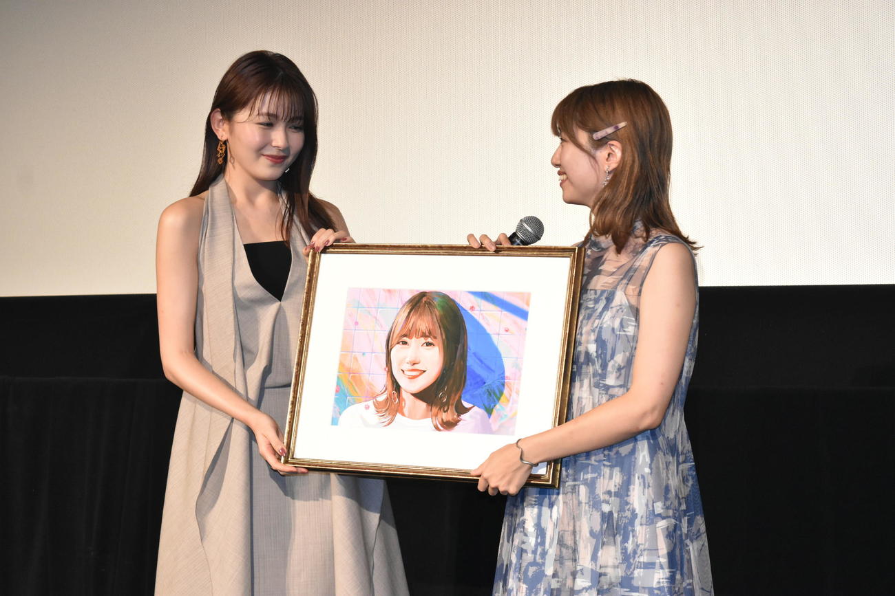 映画「夜が明けたら、いちばんに君に会いにいく」大ヒット御礼舞台あいさつに登壇し、酒井麻衣監督（右）にサプライズで美術家の朝霧レオ描きおろしの肖像画をプレゼントする主演の久間田琳加