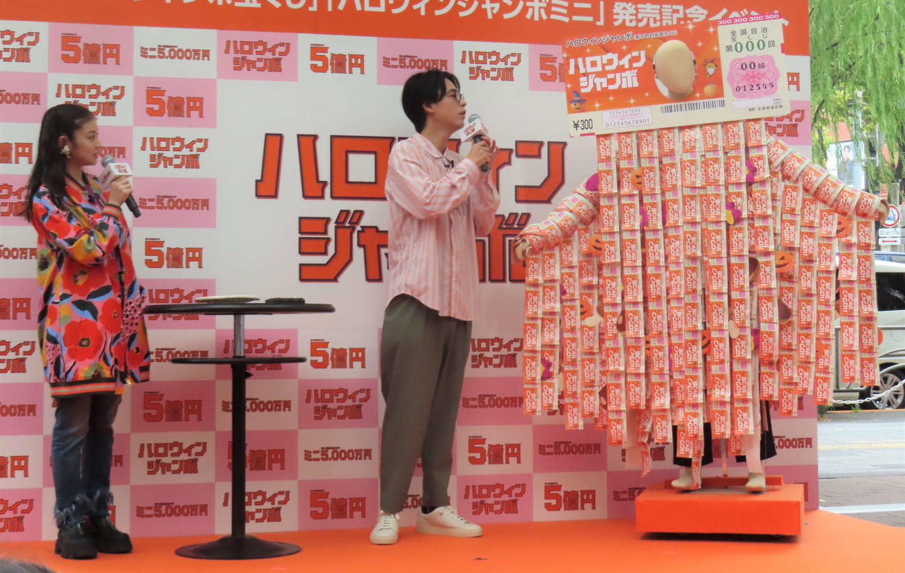 CMに登場するハロウィンジャンボマンの衣装を見つめる今田美桜（左）と成田凌
