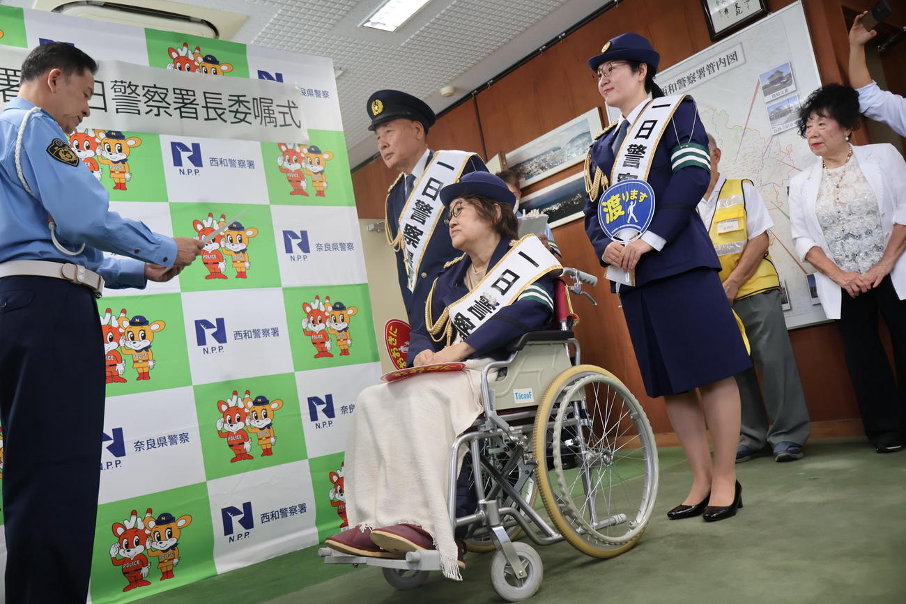 西和警察署の山村和久署長から一日警察署長を委嘱される宮川花子（手前）夫大助（奥）長女さゆみ（撮影・村上久美子）