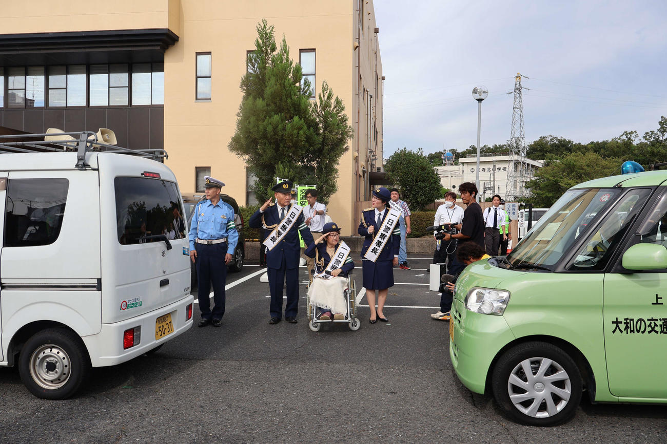 啓発活動へ出発する警察車両を見送る宮川花子（前列中央）夫大助（後方左）長女さゆみ（同右）ら（撮影・村上久美子）
