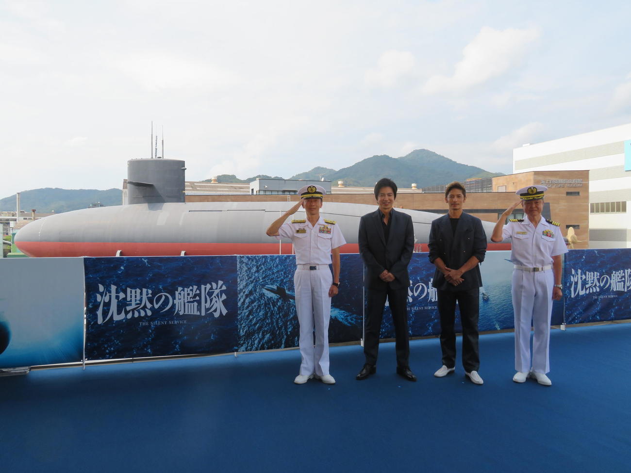 映画「沈黙の艦隊」の撮影を行った広島県呉市の海上自衛隊呉史料館「てつのくじら館」で潜水艦「あきしお」を背に笑顔の、左から海上自衛隊呉地方総監の二川達也海将、大沢たかお、玉木宏、第1潜水隊群司令の植田康照1等海佐（撮影・村上幸将）