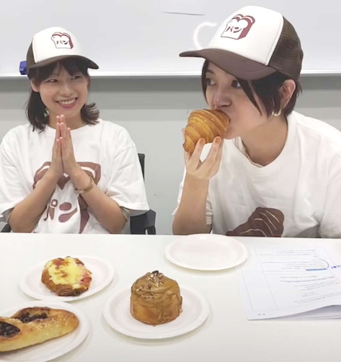 テレビ東京公式インスタグラムでのライブ配信でパンを試食する宣伝部員で漫画家の真船佳奈氏（右）と同部新入社員の矢野由磨氏