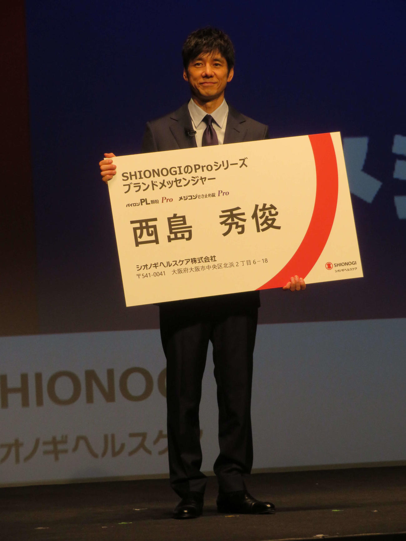 シオノギヘルスケアの、SHIONOGIのProシリーズ新CM発表会で名刺を受け取り、笑顔の西島秀俊（撮影・村上幸将）