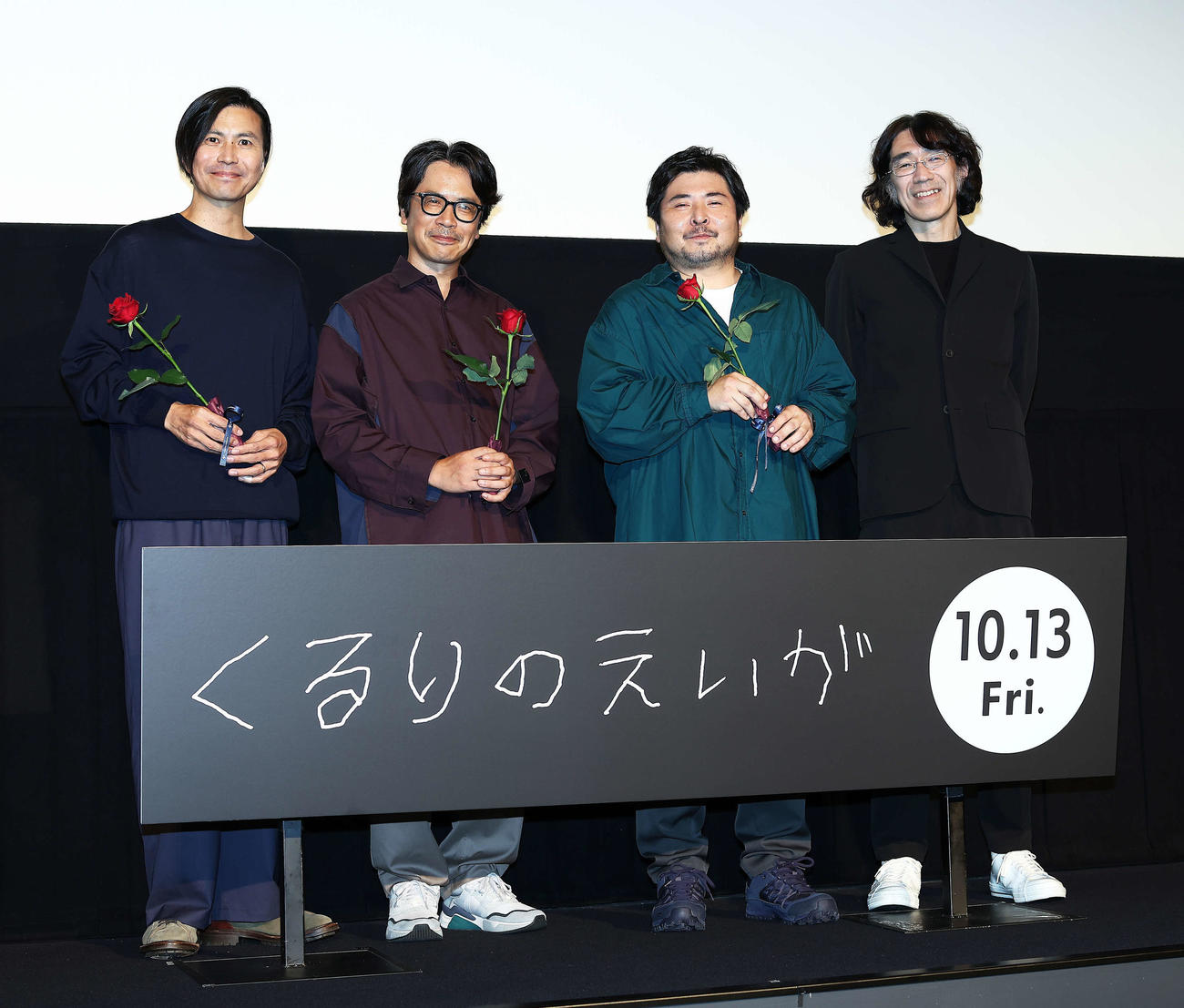 映画「くるりのえいが」完成披露上映会舞台あいさつで写真に納まるくるりの、左から佐藤征史、岸田繁、元メンバーの森信行、佐渡岳利監督（撮影・河田真司）