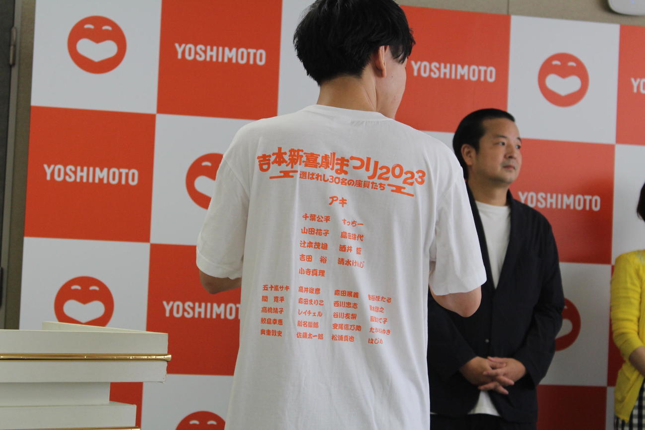 吉本新喜劇まつりを記念して発売されるTシャツを着た新名徹郎