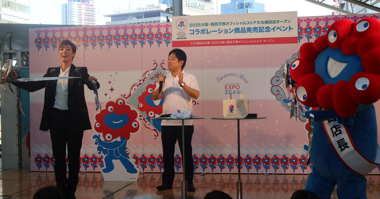 シャンシャンを手に、ミャクミャクに見本を見せる月組スター風間柚乃（撮影・村上久美子）