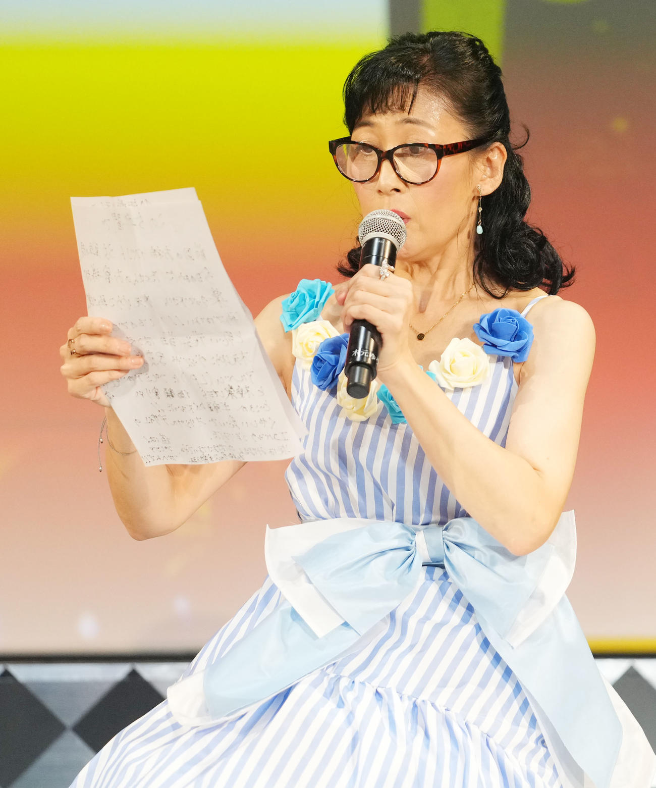 老眼鏡をかけメッセージを読む木元ゆうこ（撮影・横山健太）