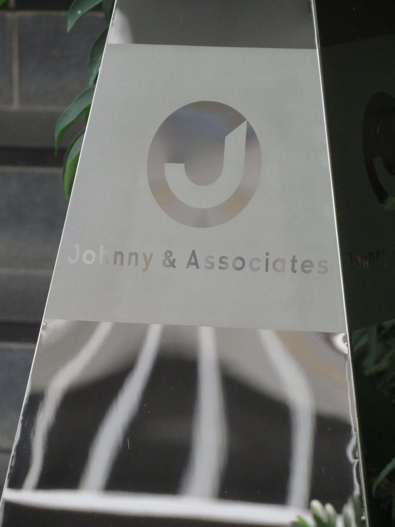 ジャニーズ事務所本社の1階エントランスにある「Johnny　＆　Associates」と書かれたシルバーの看板（撮影・村上幸将）