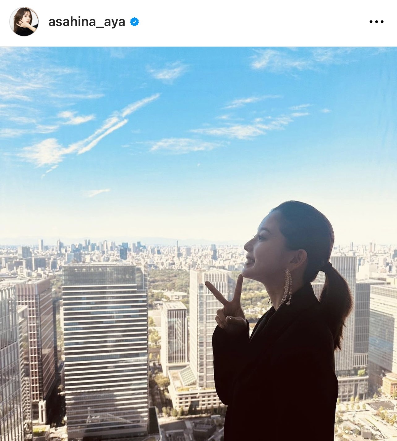 青空とビル群をバックにピースする朝比奈彩（朝比奈彩のインスタグラムから）