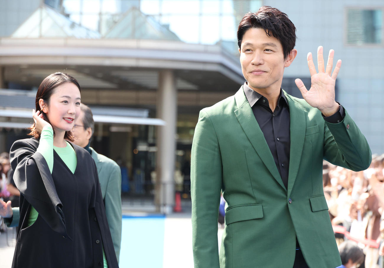 ブルーカーペットで声援に手を振り応える鈴木亮平（右）と黒木華（撮影・中島郁夫）