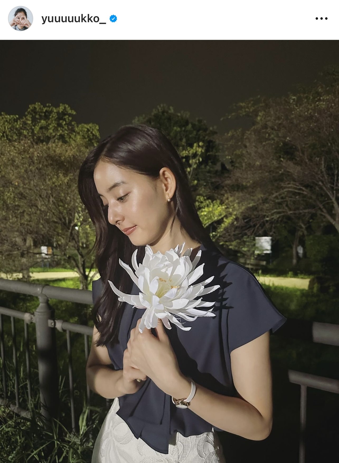 ネイビーのブラウス姿で菊の花を手にする新木優子（新木優子のインスタグラムから）