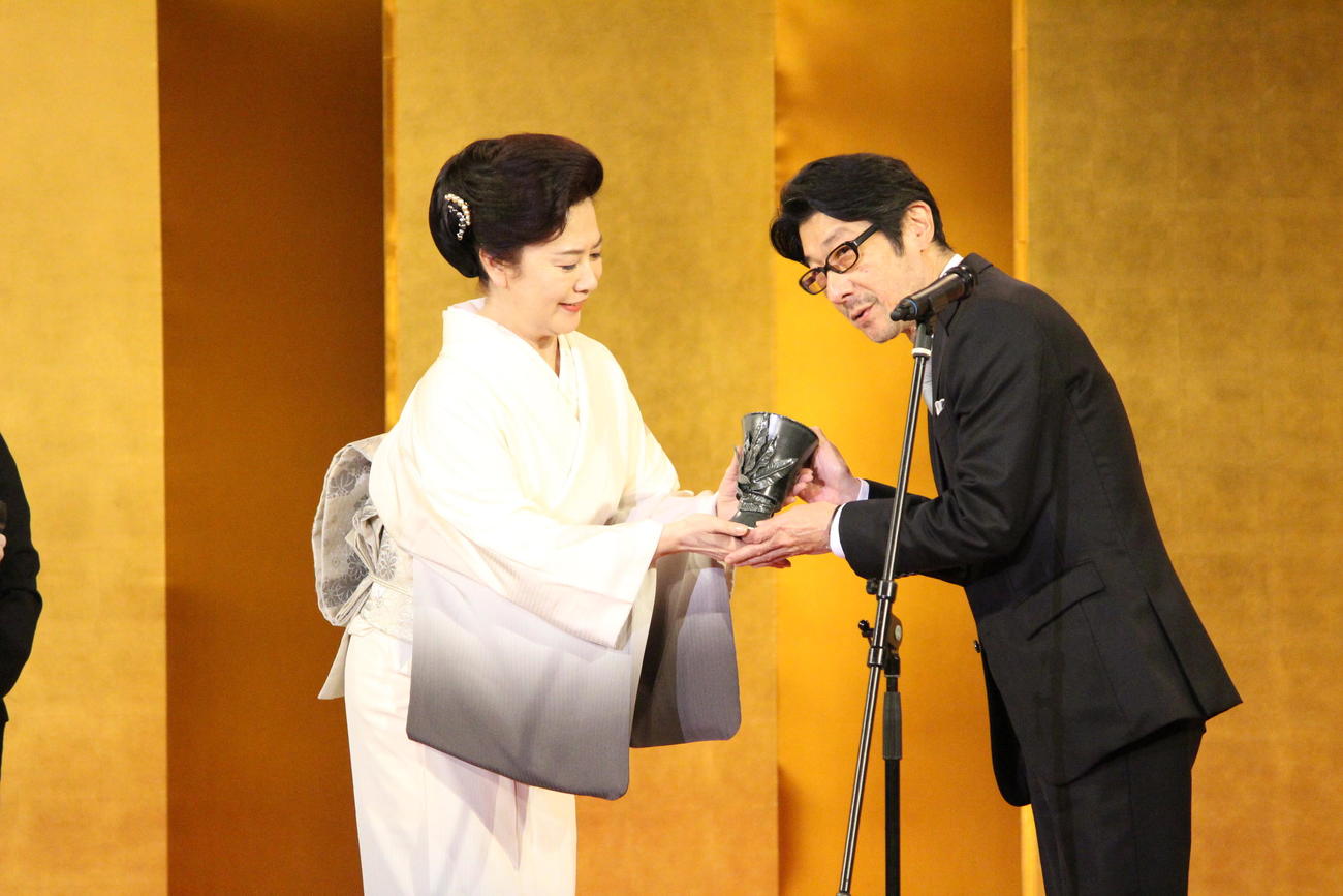 名取裕子からトロフィーを受け取る阪本順治監督