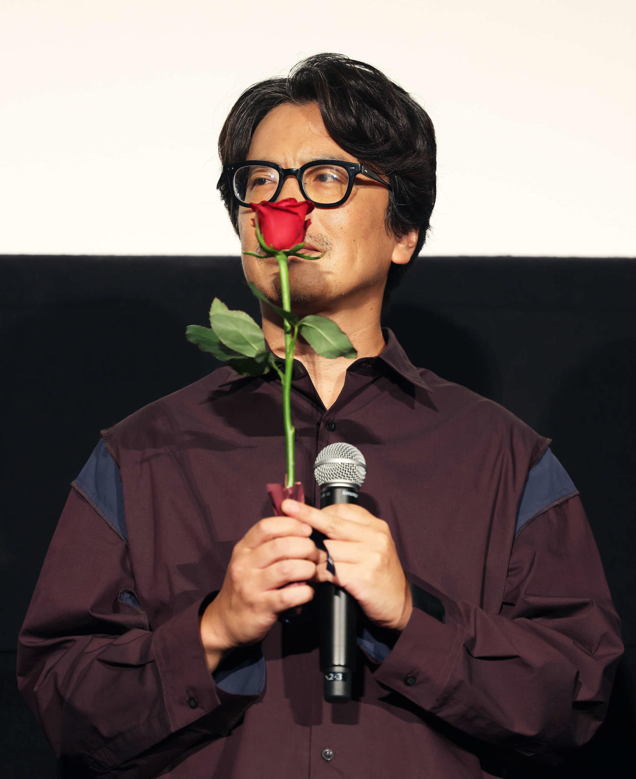 佐渡岳利監督からサプライズプレゼントされたバラの花を手にする岸田繁（撮影・河田真司）