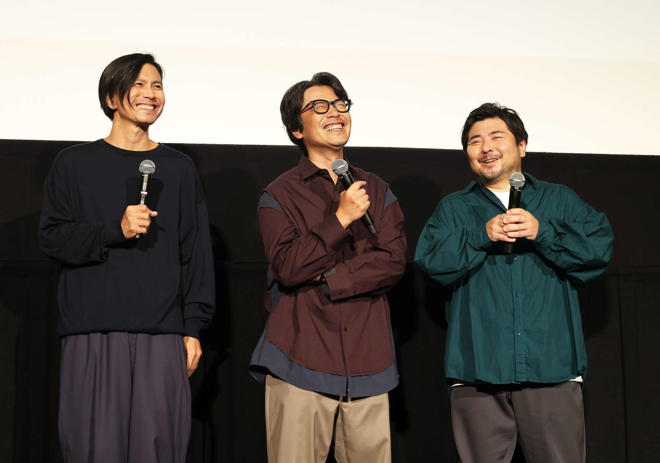 映画「くるりのえいが」完成披露上映会舞台あいさつで笑顔を見せるくるりの佐藤征史（左）と岸田繁。右は元メンバーの森信行（撮影・河田真司）