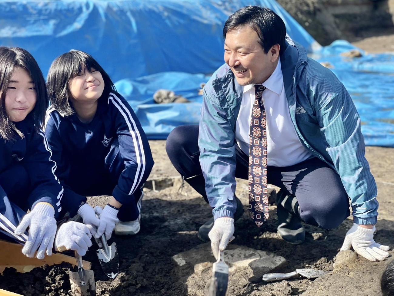 山形県新庄市の新庄城二の丸跡で、子供たちと発掘調査を行う今村翔吾氏