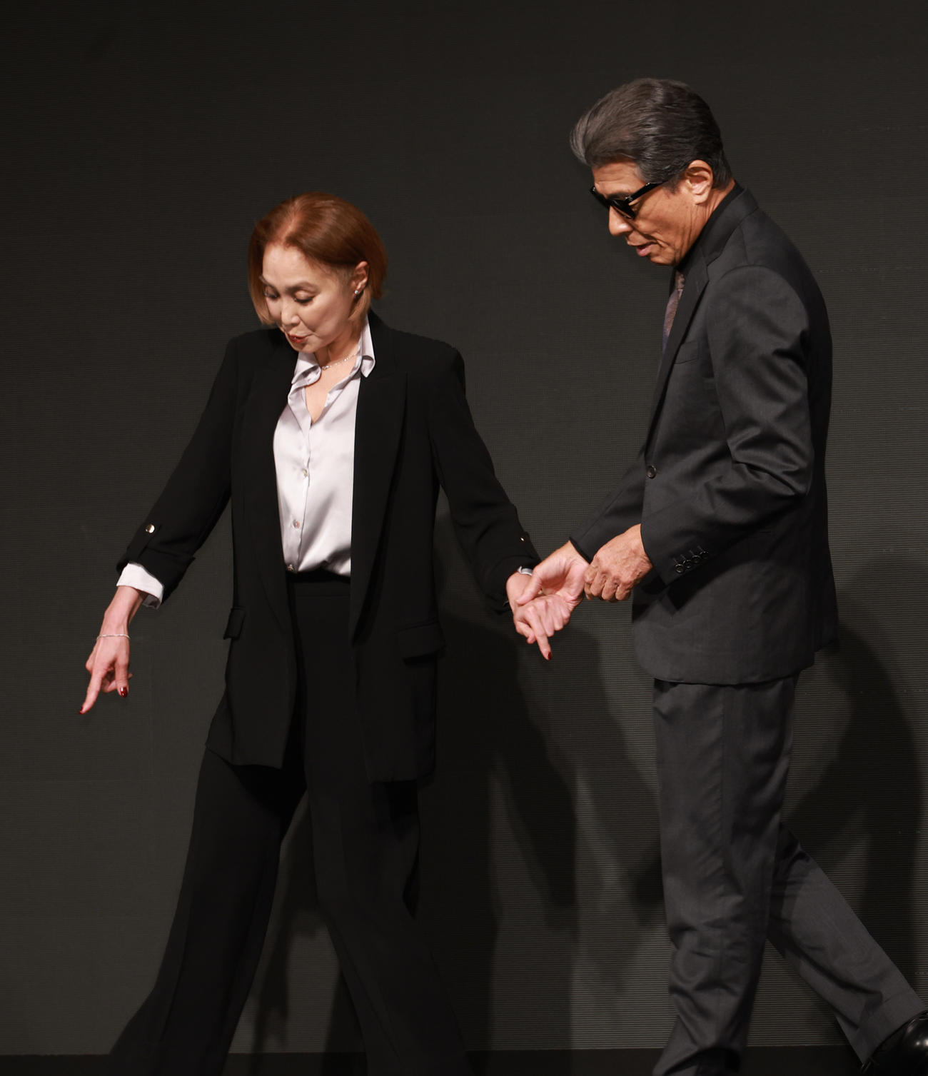 映画「あぶない刑事」製作発表で浅野温子（左）と手をつないで入場する舘ひろし（撮影・中島郁夫）